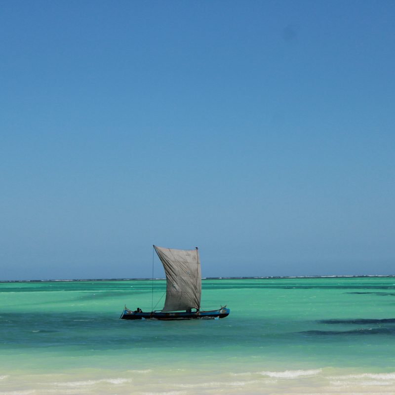 Pirogue à voile sur un lagon turquoise du Sud-Ouest